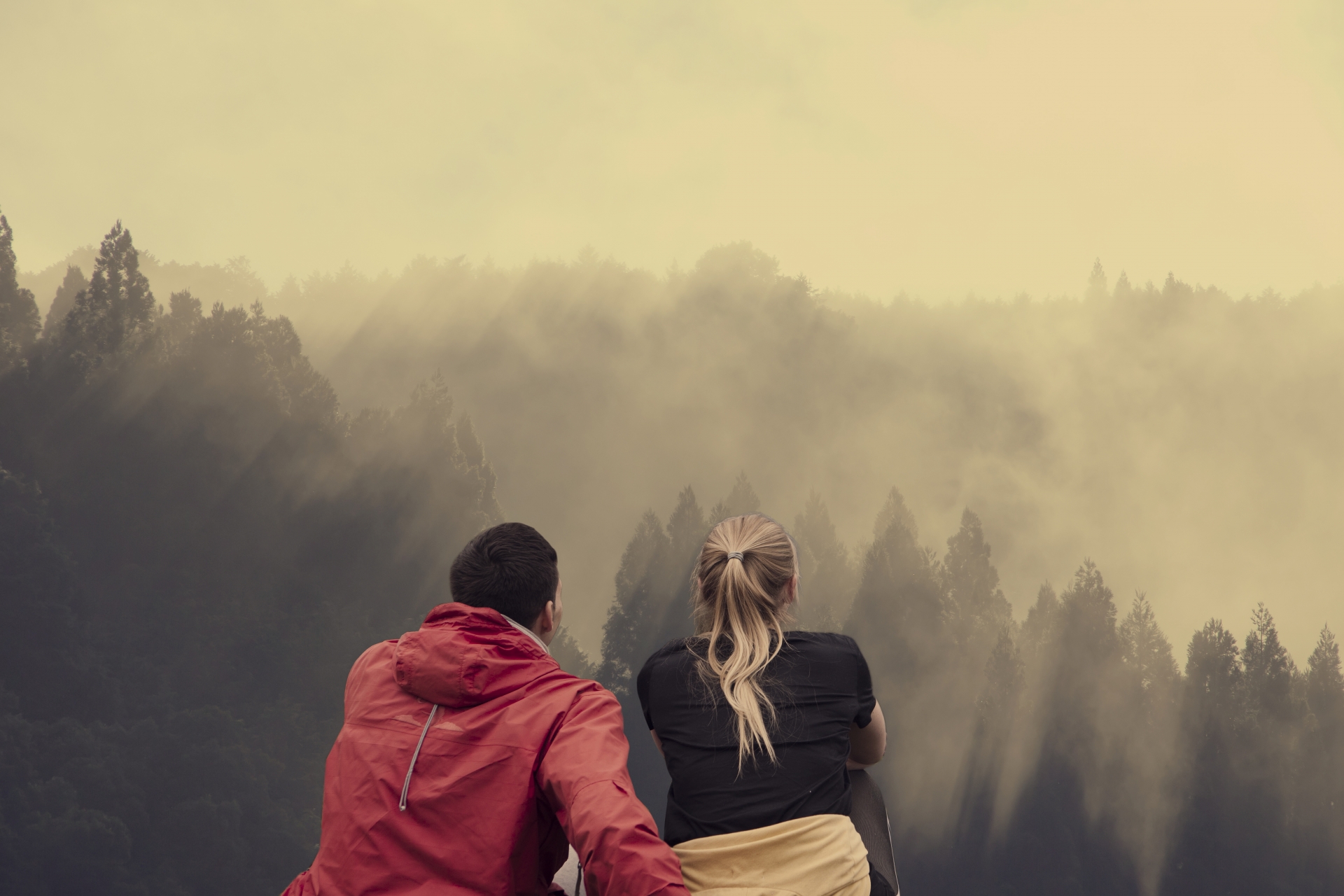 Обнимая горы. Пара сидящая на горе спиной. Фото друзей в обнимку. Два друга сидят в обнимку в горах. Горы, два человека в обнимку, размыто.