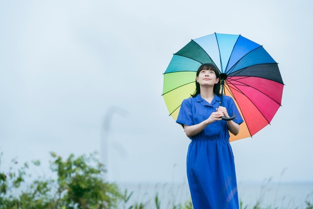 写真素材：雨の中、カラフルな傘をさす女性